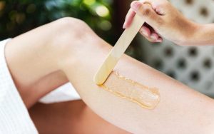 Applying sugar paste for hair removal on a leg